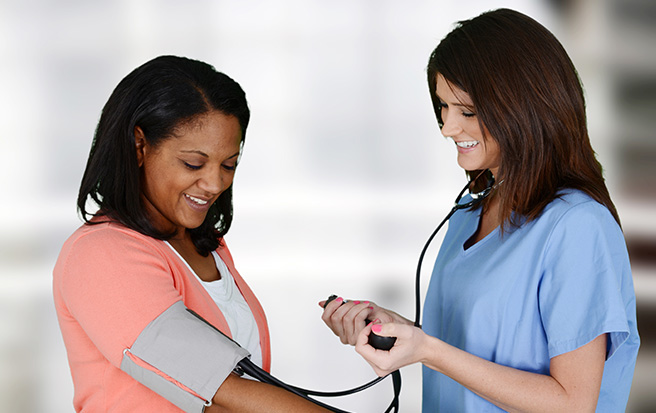 Nurse checking a woman's blood pressure