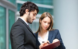 businessmen-reading-document man and woman looking at clipboard